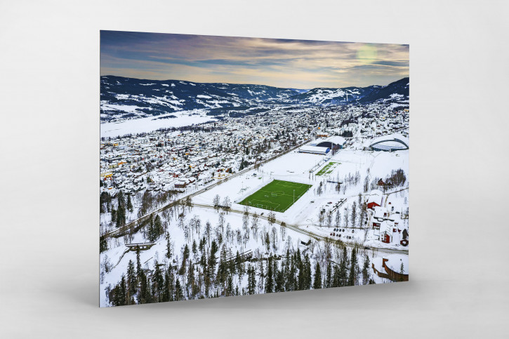 Grüne Oase in der Schneelandschaft von Lillehammer - Fußballplatz Foto als Wandbild