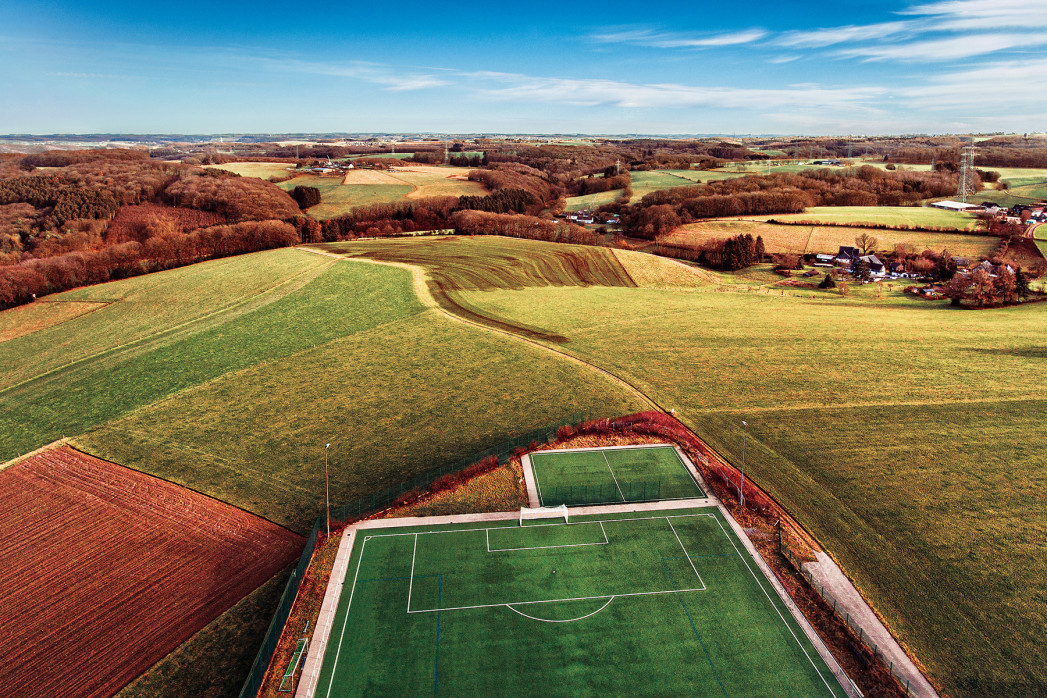 Fußballplatz in Feld-, Wald- und Wiesenlandschaft - Wandbild