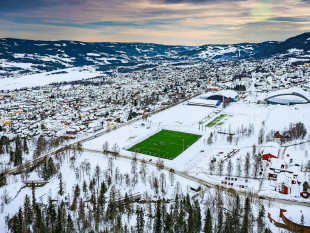 Grüne Oase in der Schneelandschaft von Lillehammer - Fußballplatz Foto als Wandbild
