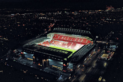 Wandbild: Anfield leuchtet bei Nacht - Luftbildaufnahme des Stadions vom FC Liverpool
